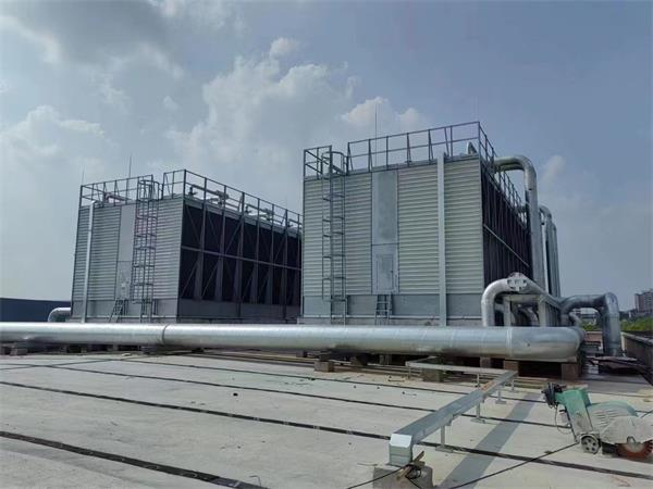 What is the difference in principle between open cooling towers and closed cooling towers?